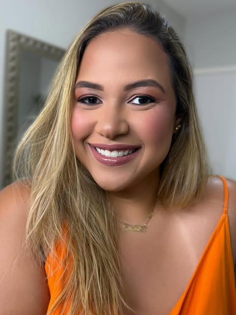 Cliente com maquiagem em tons rosados e pele iluminada